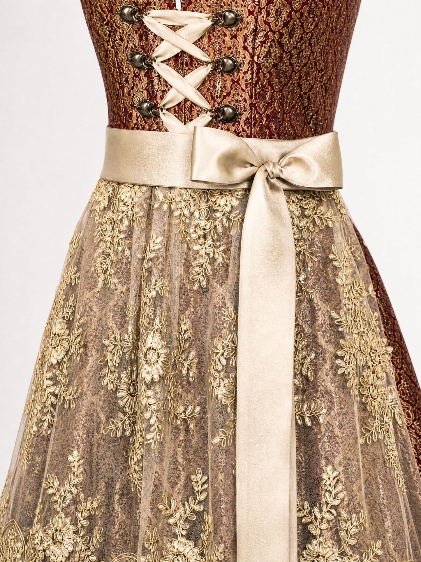 Dirndl Charlotte in Cranberryrot mit Antikgold Schürze - Detailansicht Taille und Schleife