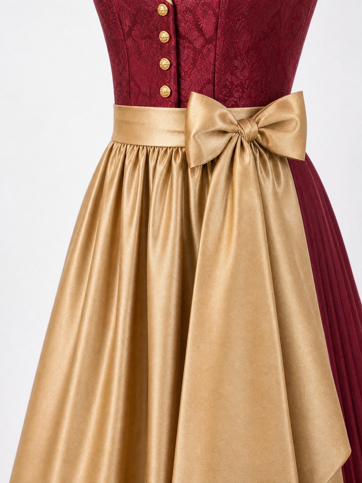 Dirndl Cecilia in Cranberryrot mit Antikgold Schürze - Detailansicht Taille und Schleife