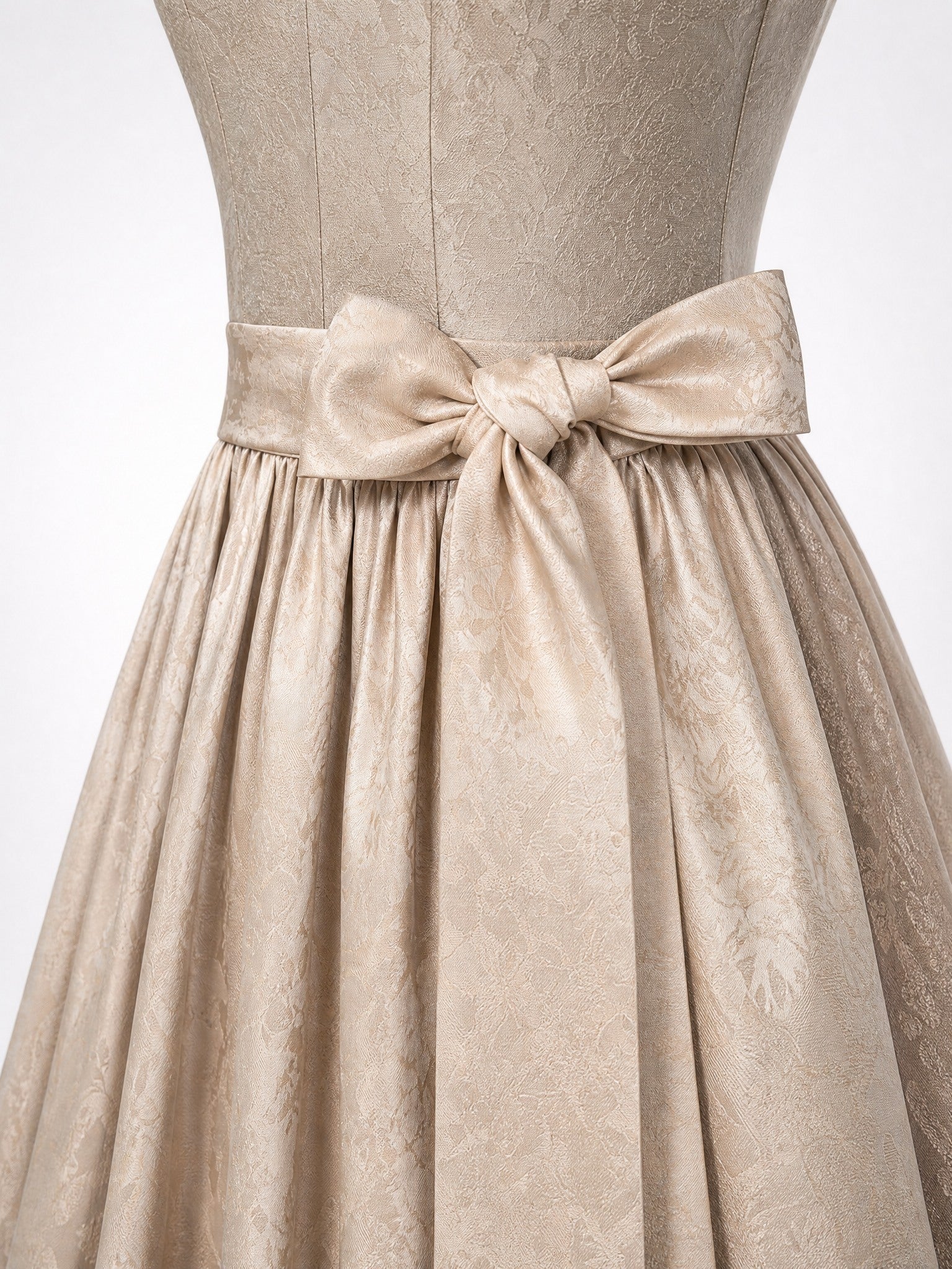 Dirndl Luisa in Beigegrau mit Champagner Schürze - Detailansicht Taille und Schleife